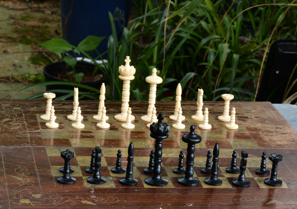Photograph of a chessboard and chess pieces set to play.