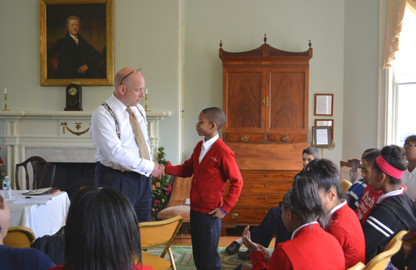 Student participant from Holy Cross School located in Mount Airy shakes hands with Lawyer Scott Griffiths at a program on the constitution hosted by Women for Greater Philadelphia at Laurel Hill Mansion in Fairmount Park on May 1st 2014.