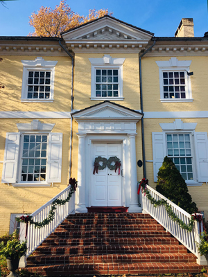 Detail of the facade of historic Laurel Hill Mansion showing the front doors decorated with the 2023 holiday wreaths to welcome visitors 