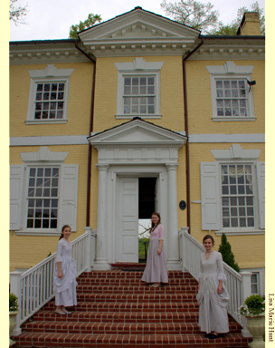 Photograph of three young women in colonial garb on the front steps of Laurel Hill Mansion.  A historic house in Philadelphia's Fairmount Park that is open to the public weekly from Thursday through Sunday.  There are also special events including concerts, lectures and themed events.
