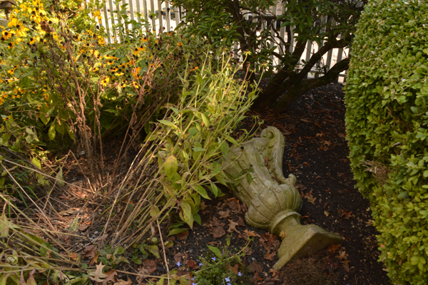 A mossy ornamental vase lies hidden in a garden at Laurel Hill Mansion.